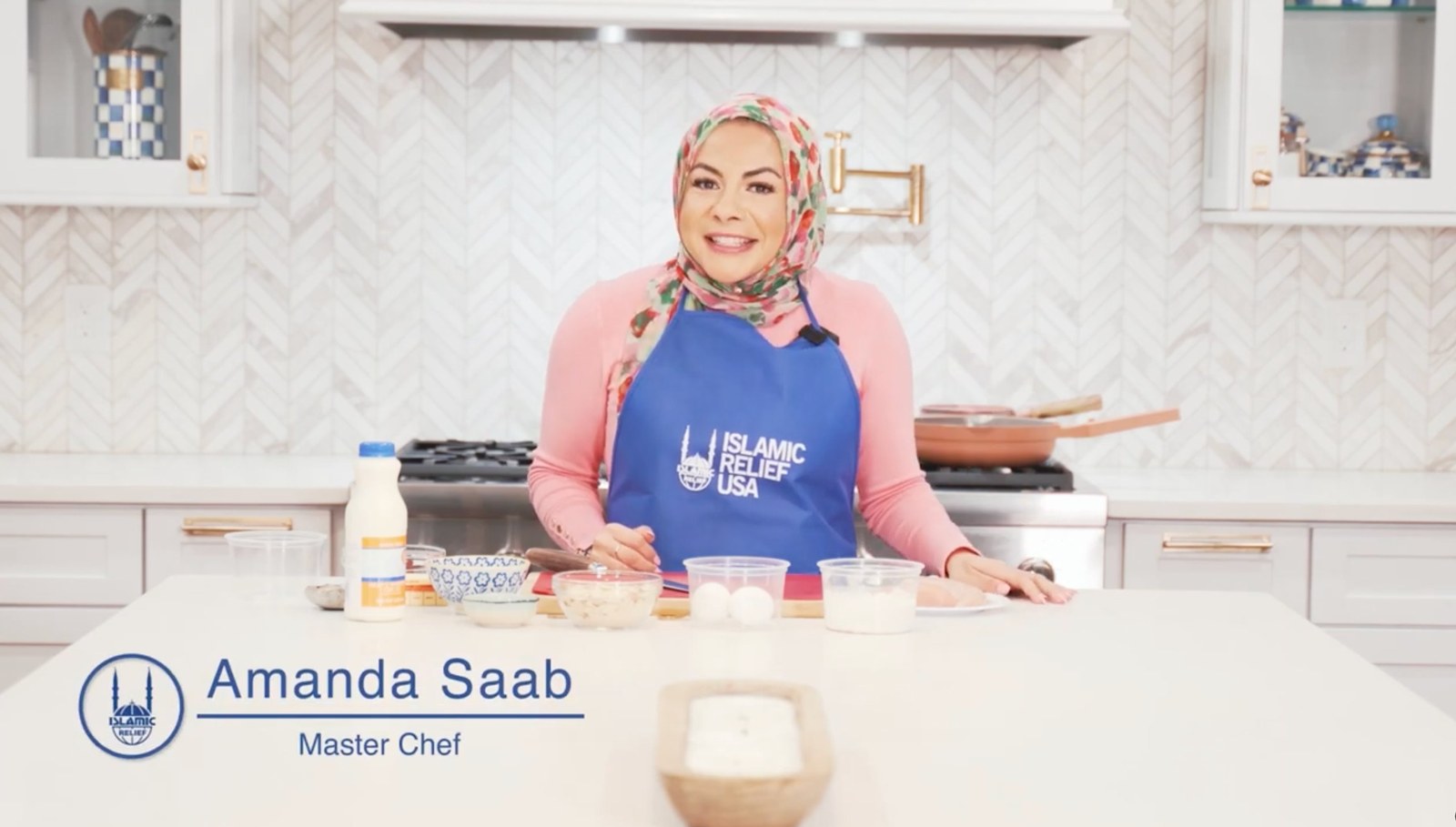 Amanda Saab in an Islamic Relief USA apron, on set for the Cooks for a Cause series
